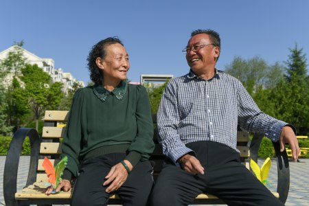 5月20日,高素芬(左)和老伴儿张建平坐在新园广场内的长椅上休息.