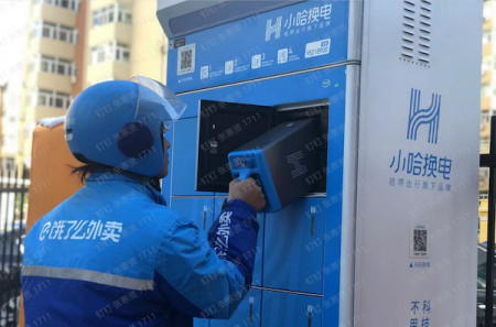 图说:一名外卖骑手正在小哈换电柜给电动车换电池采访对象供图新民